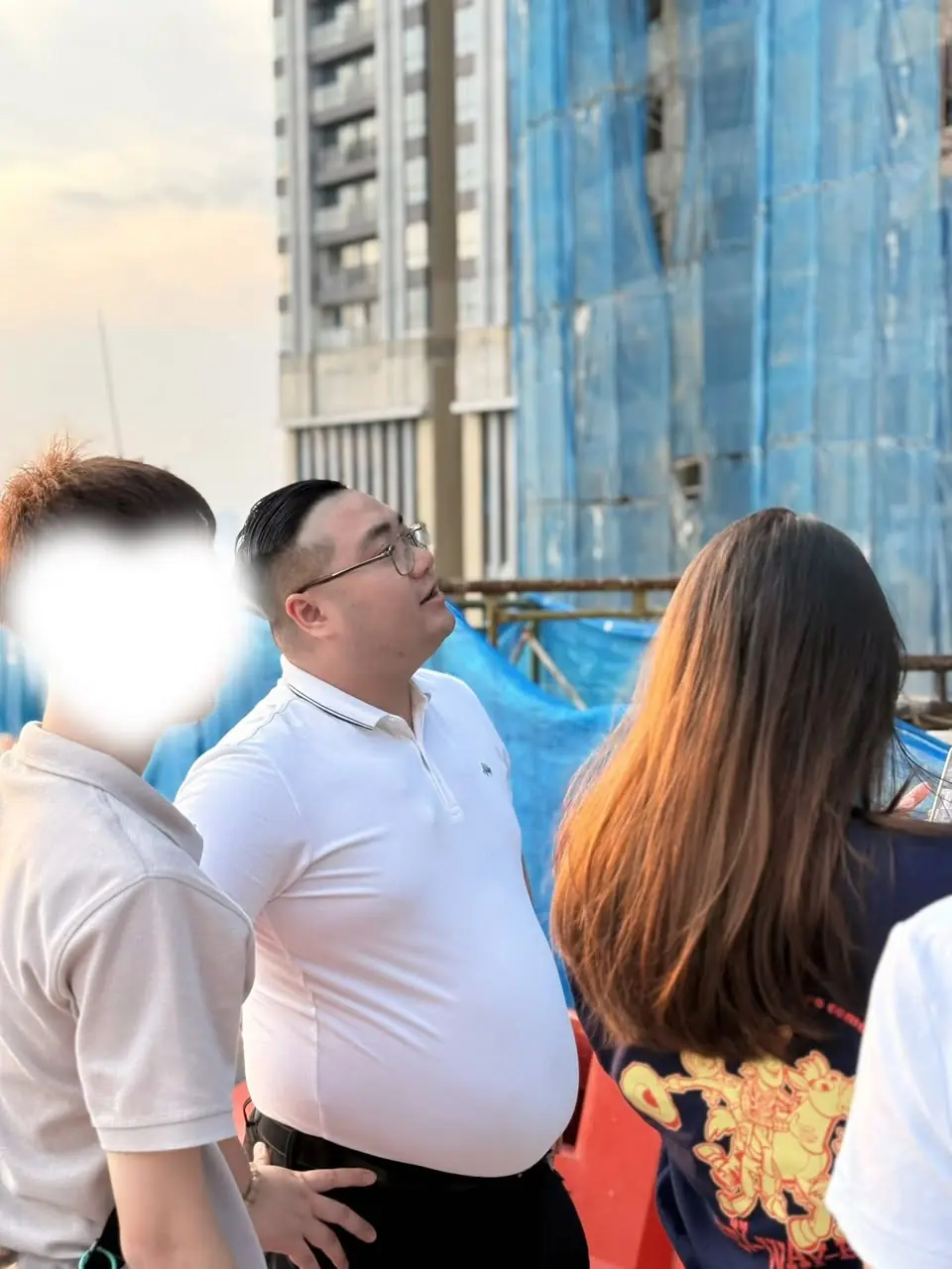 师傅在建筑工地仰望新楼,观察外局
