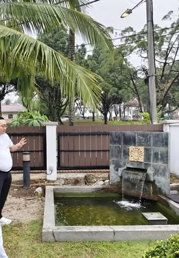师傅在庭院水池旁讲解水局